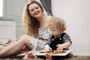 samimi ve neşeli bir aile, kıvırcık genç bir anne küçük oğlu yanına oturur, birlikte vakit geçirmek