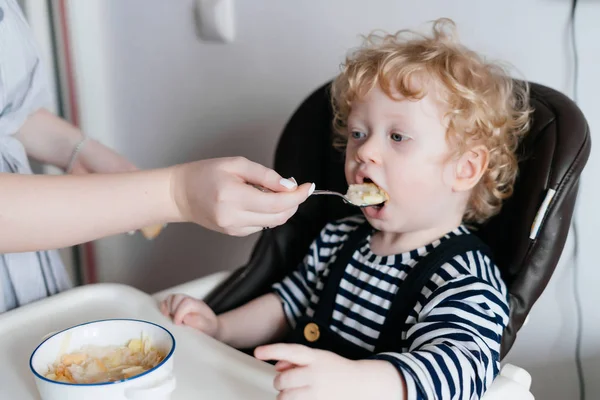 bakım iyi anne küçük kıvırcık çocuk oğlu lezzetli bir çorba ile beslenir.
