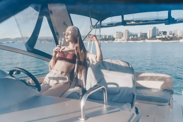 A rich luxury woman enjoys a holiday on her yacht, drinks champagne and sails on the Caribbean sea — Stock Photo, Image