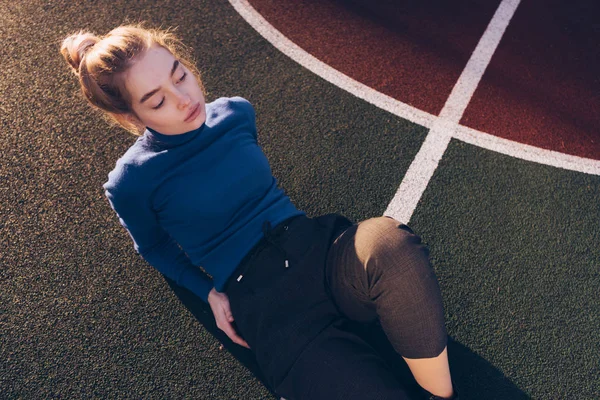 Menina loira atraente elegante posando no campo de esportes ao ar livre — Fotografia de Stock