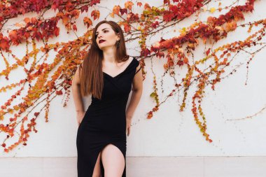 siyah uzun elbiseli onu bahçede dinlenme ve duvara poz lüks seksi kız