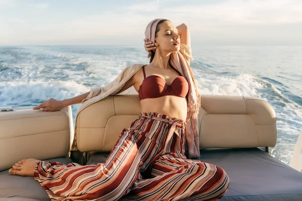 Şık yaz pantolonlu güzel bir kız güneşin adalarına yelken bir yatta sıcaklık ve tatil sahiptir — Stok fotoğraf