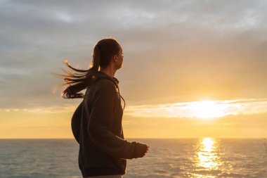 emin uzun saçlı kız günbatımı, kilo vermek istiyor, sahil boyunca çalışır