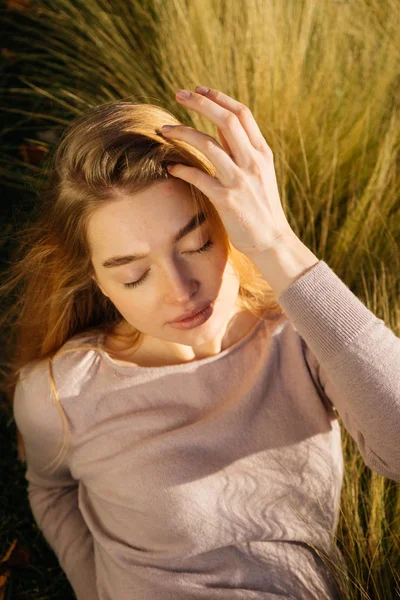 Carino ragazza modello con i capelli biondi in posa in un campo al sole — Foto Stock