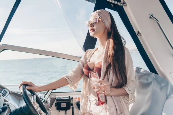 En lyxig självsäker tjej i solglasögon simmar på sin yacht vid Karibiska havet, drycker dyra champagne — Stockfoto