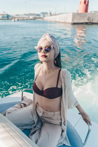 En rik vacker kvinna i solglasögon kör sin yacht, en efterlängtad semester till havs — Stockfoto