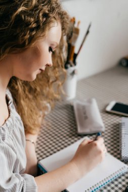 güzel kıvırcık kadın ressam boyalar bir defter, sanat seviyor
