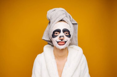 Sevimli Genç kız başında duş gülümsüyor, yüz maskesi namlu Panda ile nemlendirici sonra havlu ile