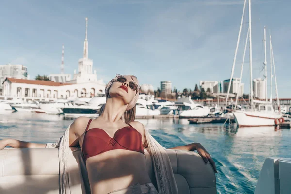 Una joven de lujo en un traje de baño elegante se relaja en su yate, navega en el mar Caribe — Foto de Stock