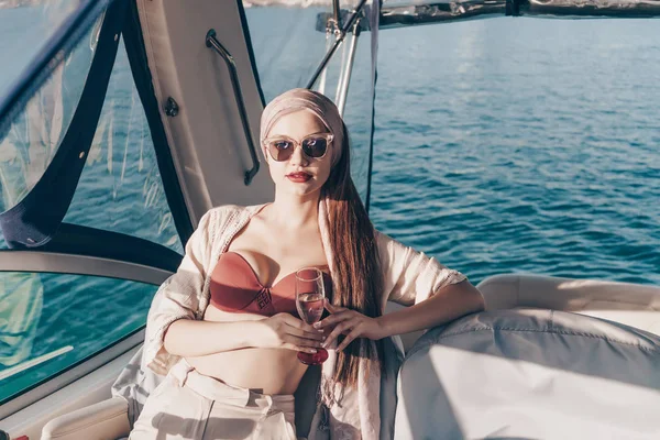 a luxurious rich woman rests and relaxes on her yacht, drinks champagne and sails to the island