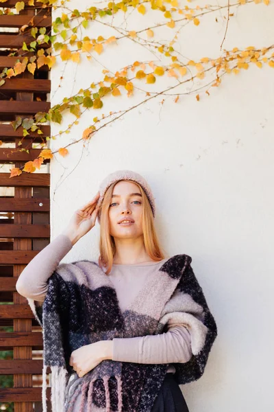 Attraktiv ung blond flicka i rosa hatt poserar mot vägg bakgrund, leende — Stockfoto