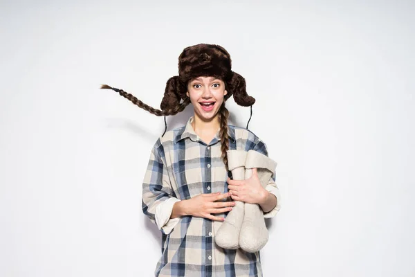 Grappige jong Russisch meisje met pigtails verheugt zich in de winter houdt grijs voelde laarzen — Stockfoto