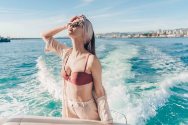 bir tatil ve zengin bir hayat zevk güzel ince kadın güneş, bir gemide poz başında başörtüsü ile
