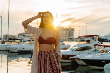 şık pantolonlu güzel uzun saçlı kız seaport güneşte keyif alıyor. gülümsüyor