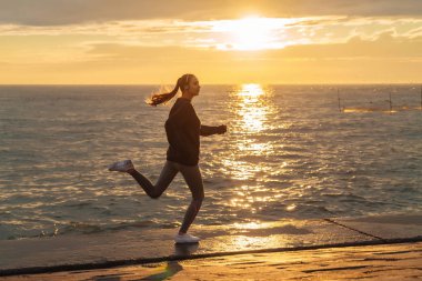 bir maraton için hazırlanıyoruz gün batımında, deniz çalışan ince hızlı kız
