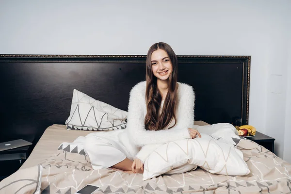 Feliz sonriente chica de pelo largo en pijama se despertó temprano en la mañana de buen humor — Foto de Stock