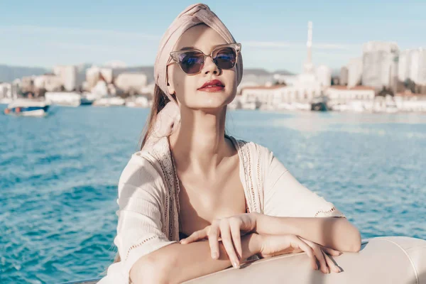Una atractiva mujer rica en gafas de sol nada en el mar Caribe, disfruta de unas vacaciones —  Fotos de Stock