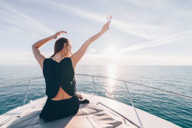 siyah yaz giysileri güzel şık kızı onun beyaz yatta oturur, deniz yolculuğu sahiptir