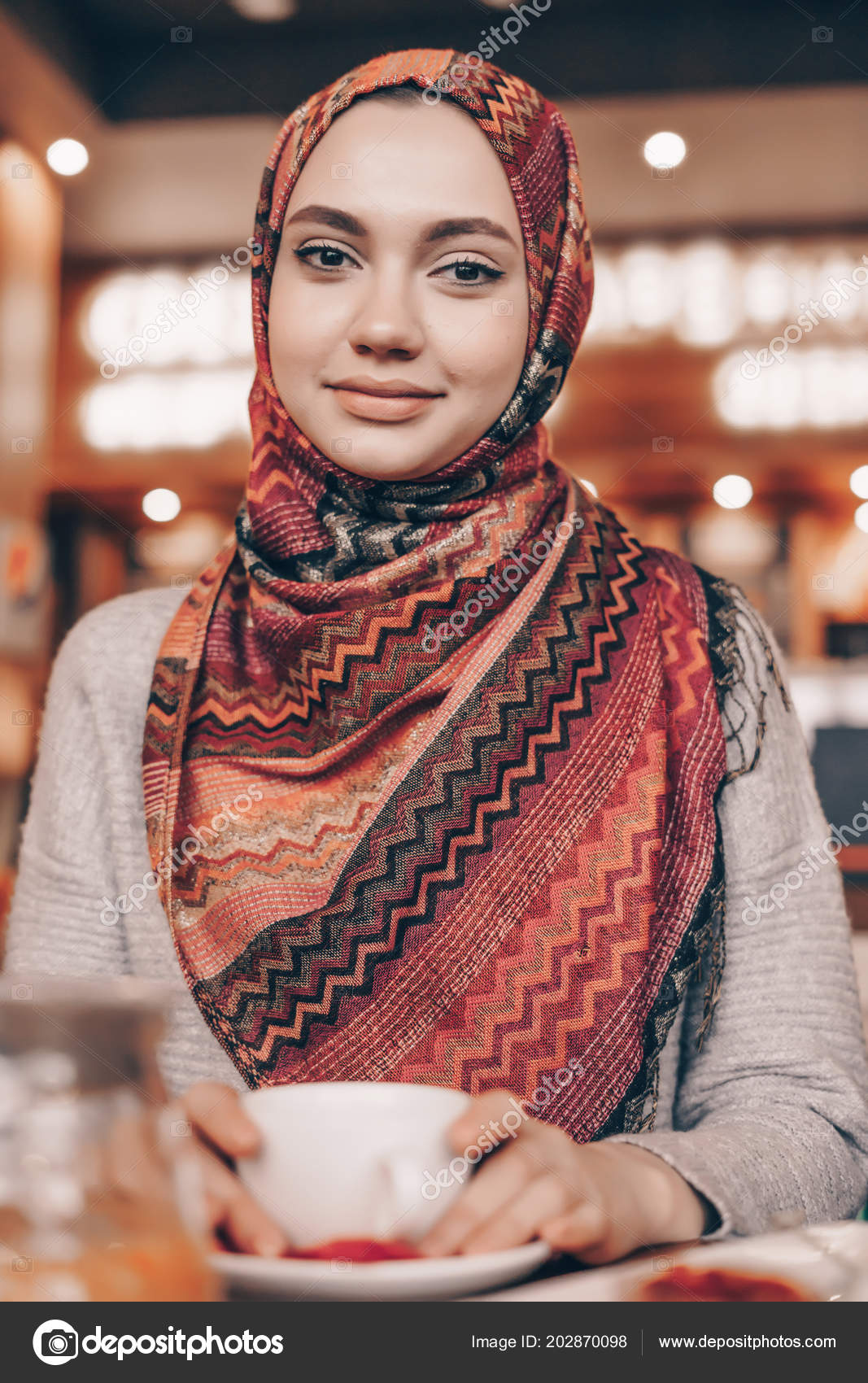 Charming Arab Girl With A Beautiful Headscarf At Her Dinner In A Cozy Cafe Looks At The Camera And Smiles Stock Image Charming Arab Girl With A Beautiful Headscarf At Her Dinner In A Cozy Cafe Looks At The Camera And Smiles Stock Image