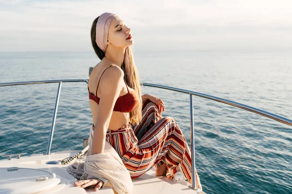 Una chica elegante de lujo en ropa de verano de moda descansa en un yate, navega en el mar Caribe —  Fotos de Stock
