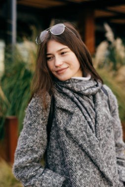 gri paltolu bir yürüyüş ve bulutlu hava, zevk esmer kız sevimli gülümseyen