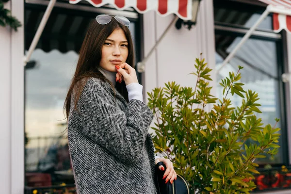 Charming urban girl brunette in gray coat walking and posing outdoors — Stock Photo, Image