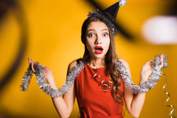 Linda chica sorprendida en vestido rojo celebrando año nuevo y Navidad, oropel — Foto de Stock