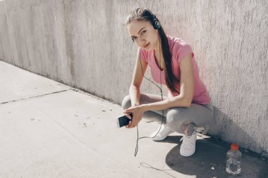 kulaklıklar müzik dinlemek kendine güvenen kız güzel güneşin altında poz spor giyim