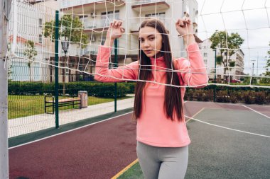 voleybol oynarken spor alanının yanındaki net, poz uzun saçlı ince kız