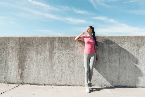 içme suyu ince spor kız önce eğitim, pembe bir T-shirt kazanıyor gücü