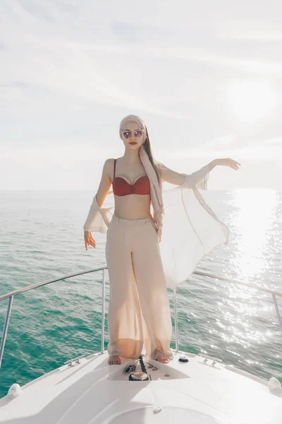 Hermosa chica alta en gafas de sol posando en un yate blanco, disfrutando de una aventura de mar —  Fotos de Stock