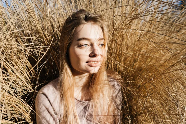 Bonito sorrindo menina loira modelo posando no sol na grama — Fotografia de Stock