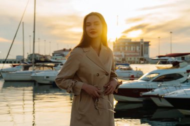 akşam güneşin bir liman poz şık bir ceket uzun saçlı lüks güzel kız gülümseyerek