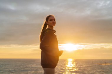 uzun saçlı kız bir gün batımında için denize gitti emin gülümseyen, spor sever