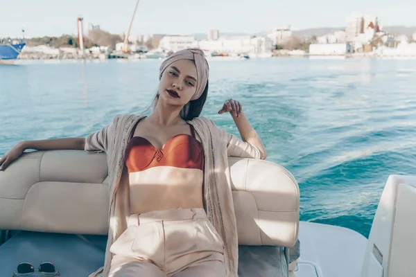 Una chica atractiva y elegante disfruta de una vida rica en su yate, navega a la isla —  Fotos de Stock