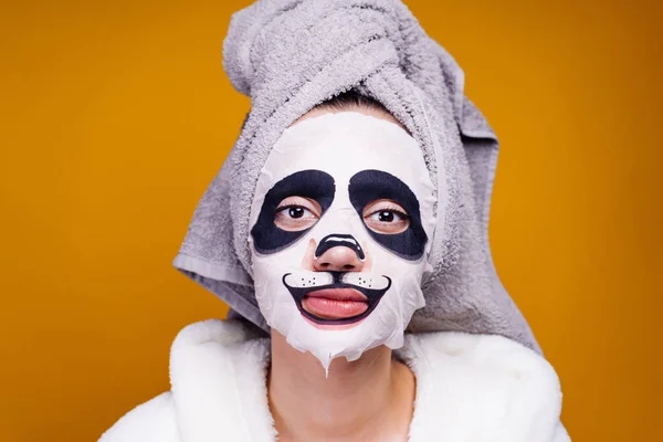 Charming girl after shower, posing, on face moisturizing mask with muzzle of panda — Stock Photo, Image