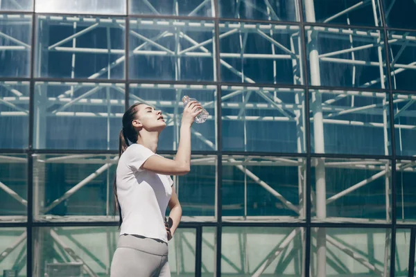 ince atletik kız eğitimden sonra suyu içer, aktif bir yaşam tarzı yol açar