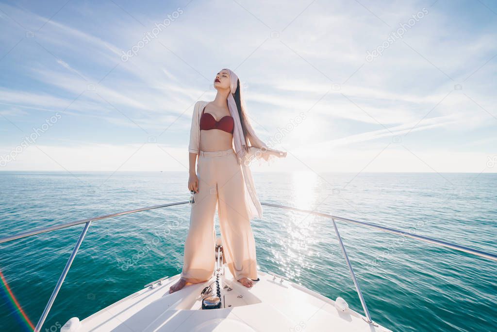 luxurious stylish girl posing on her yacht in the sun, sailing the Caribbean sea