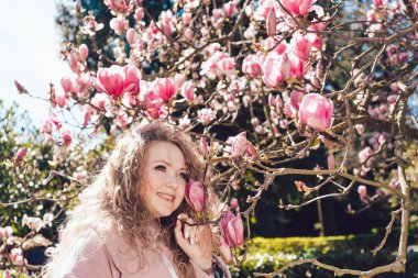 sıcaklık ve güneş çiçek açan bir Manolya arka planı poz güzel zarif kadının