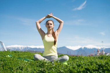 düzgün sakin kız yoga yapan ve güneşin oturur yeşil çimenlerin üzerinde derin derin düşünür