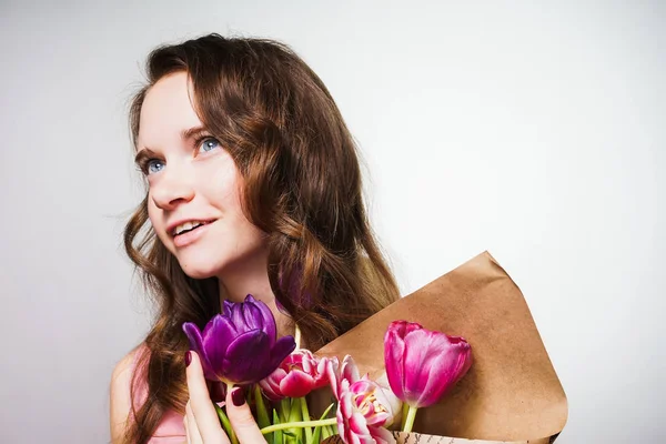 çekici güzel kız güzel kokulu çiçekler büyük bir buket tutar, bakar ve gülümser