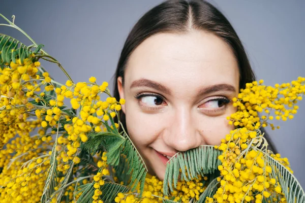 güzel kokulu sarı Mimoza yanında poz komik genç kadın