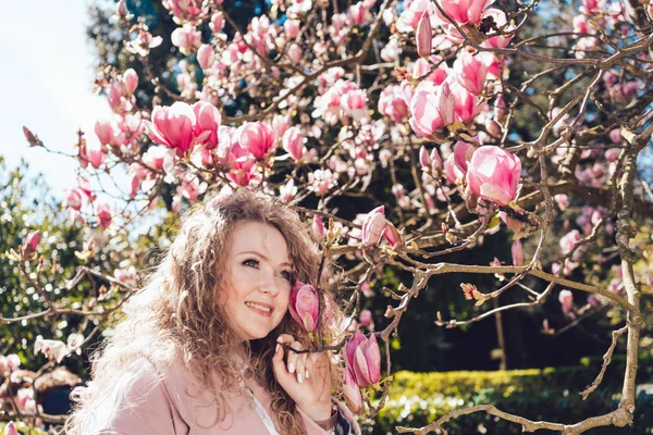 sıcaklık ve güneş çiçek açan bir Manolya arka planı poz güzel zarif kadının