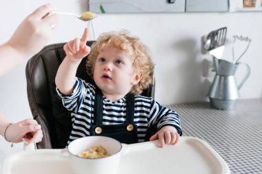 Anne beslemeleri kıvırcık oğlunun lezzetli ve sağlıklı yemek mutfakta, birlikte öğle yemeği