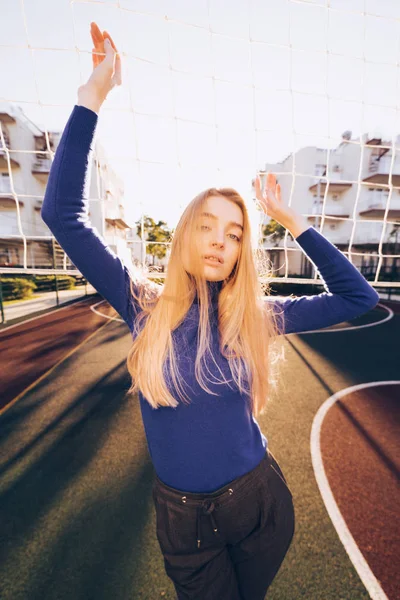 mavi kazaklı güneşte net voleybol spor tarlada poz lüks şık sarışın kız