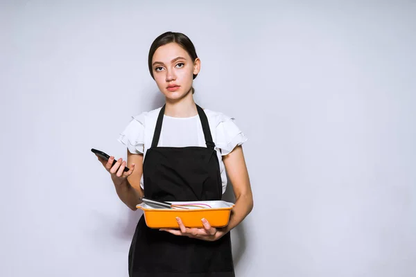 young woman chef chef in black apron preparing delicious pie
