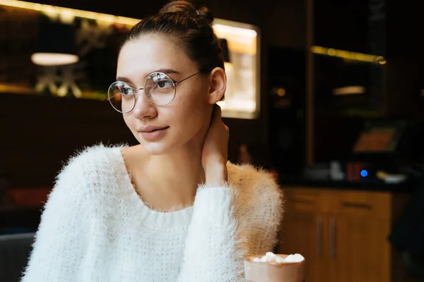 Очаровательная молодая девушка фрилансер в очках и белый кофе отдыхает от работы, в кафе — стоковое фото