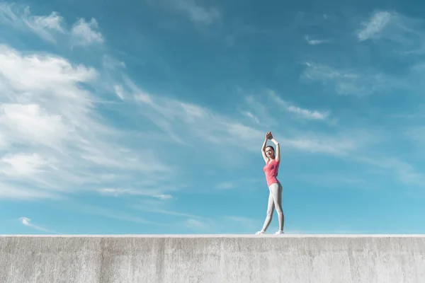 Delgada chica atlética caliente bajo el cielo azul, lleva un estilo de vida activo y saludable — Foto de Stock