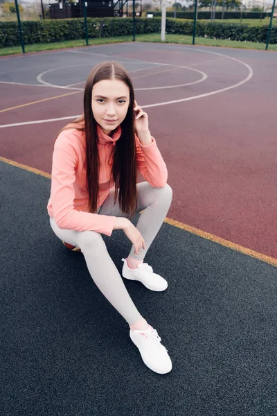 Впевнена довгошерста дівчина позує на спортивному полі, практикуючи — стокове фото