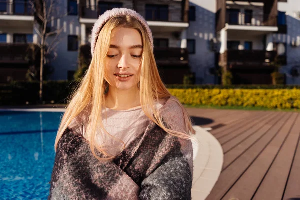 Encantadora jovem loira de chapéu gosta de relaxar e sol à beira da piscina, sorrindo — Fotografia de Stock